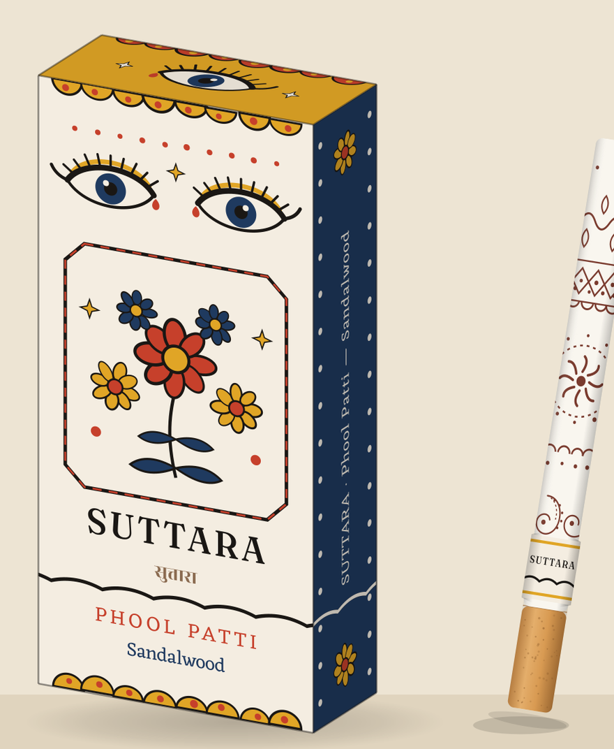 Phool Patti box — cotton white with painted flowers and kohl eyes — beside its mehndi-printed stick